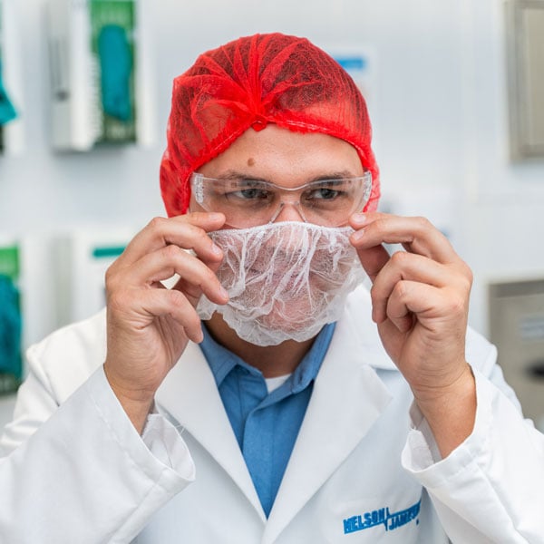 Adam-Monson-looking-off-camera-finishes-putting-on-a-beard-net