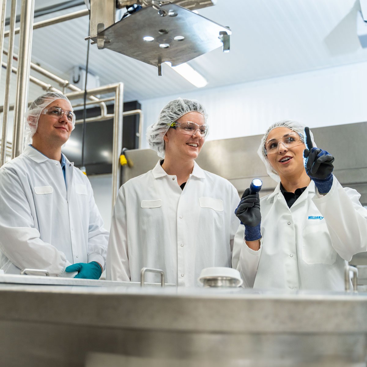 Nelson-Jameson-employee-and-customers-looking-at-plant-equipment-2