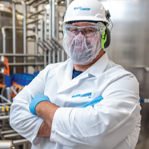 Nelson-Jameson technician in full PPE standing in an industrial washdown area.