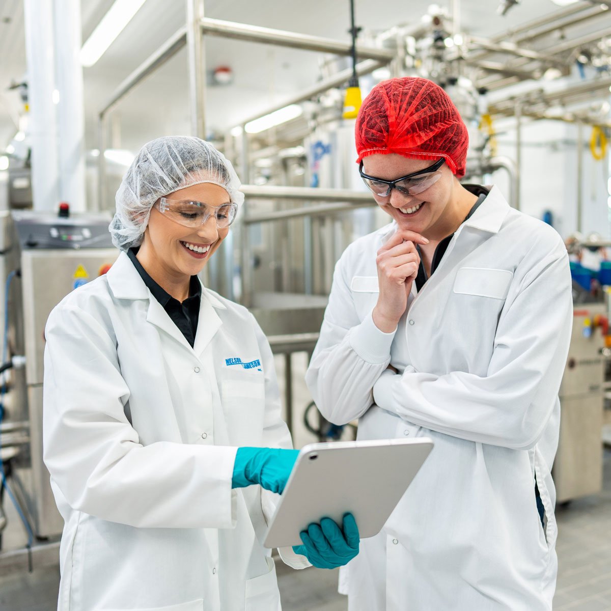 Nelson-Jameson-employee-chatting-with-customer-holding-ipad-smiling-1