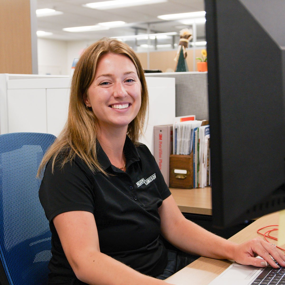 Hailey-Hoffman-smiling-sitting-at-her-desk